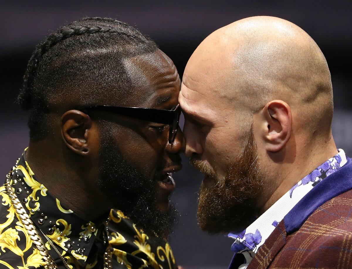 Professional boxers Deontay Wilder (L) and Tyson Fury butt heads onstage during their press conference to promote their upcoming December 1, 2018 fight in Los Angeles at The Novo by Microsoft on October 3, 2018 in Los Angeles, California.