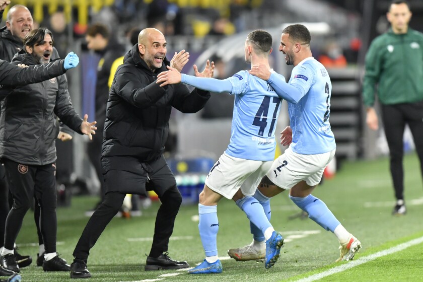 Manchester City's head coach Pep Guardiola celebrates with goal scorer Manchester City's Phil Foden during the Champions League quarterfinal second leg soccer match between Borussia Dortmund and Manchester City at the Signal Iduna Park stadium in Dortmund, Germany, Wednesday, April 14, 2021. (AP Photo/Martin Meissner, Pool)