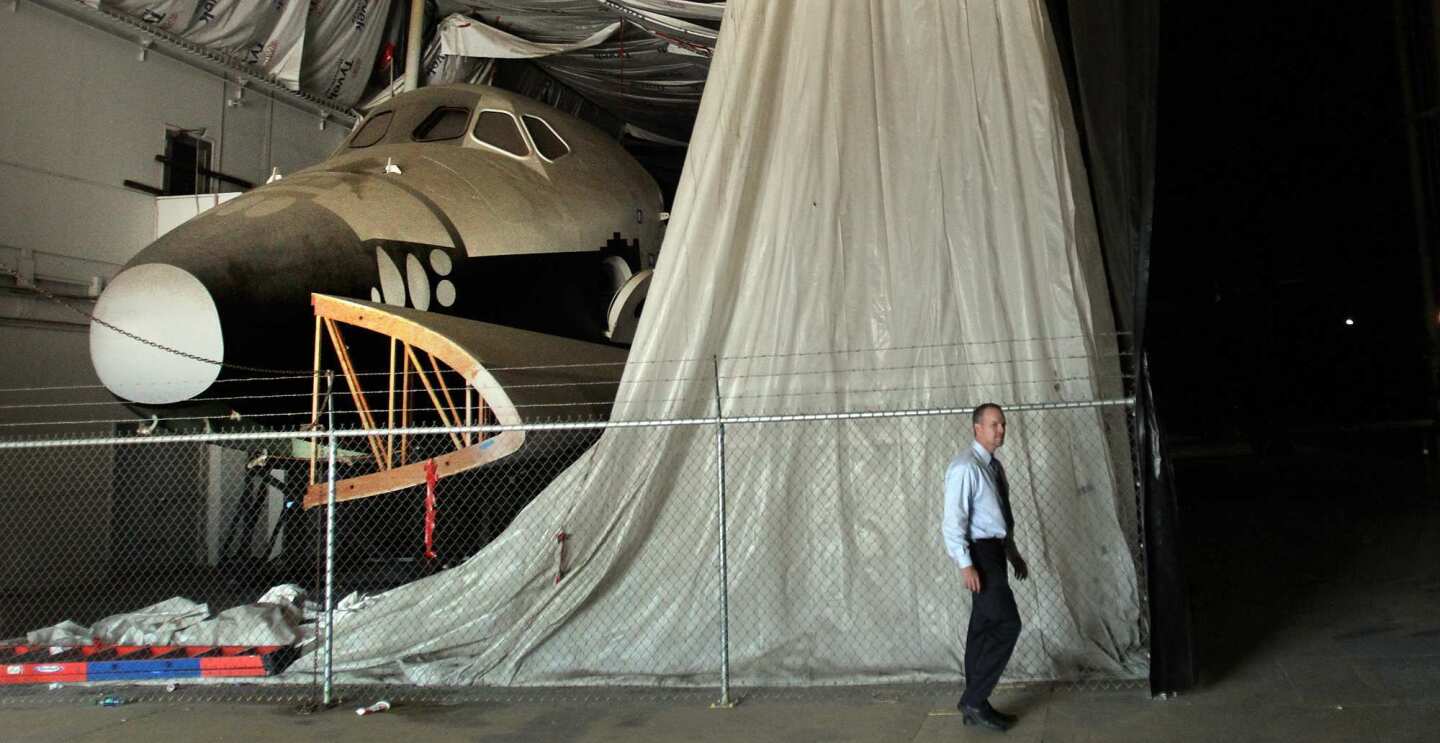 Louis Atwell of the Downey Public Works Department walks by mock-up of the space shuttle.