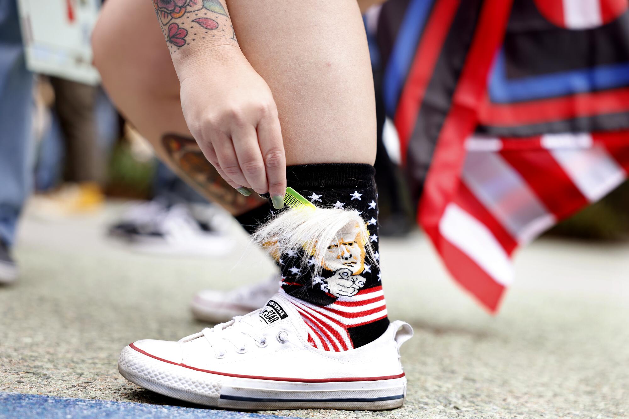 Becca Esler of Eastvale brushes the hair on her Trump socks outside of the California Republican Party Convention.