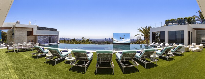 Un écran de télévision escamotable et un bar de nage accompagnent la piscine à débordement de 85 pieds de long.