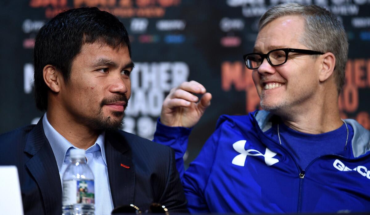 WBO welterweight champion Manny Pacquiao, left, talks with his trainer Freddie Roach during a news conference at the KA Theatre at MGM Grand Hotel & Casino on April 29.