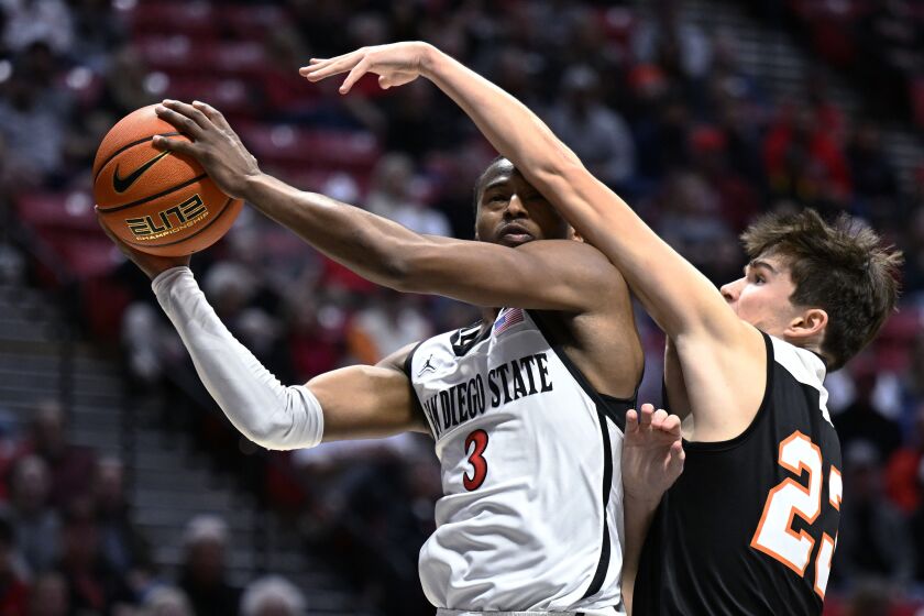 San Diego State guard Micah Parrish (3) shoots against Occidental guard Nicky Clotfelter (23) during the first half of an NCAA college basketball game Friday, Dec. 2, 2022, in San Diego. (AP Photo/Denis Poroy)