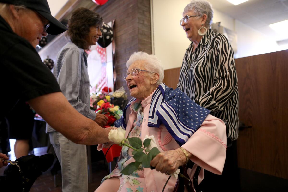 Opal Goode, center, with daughter, Cheryl Bernhardi, 80, right, greets friends at her 112th birthday party in Ridgecrest.