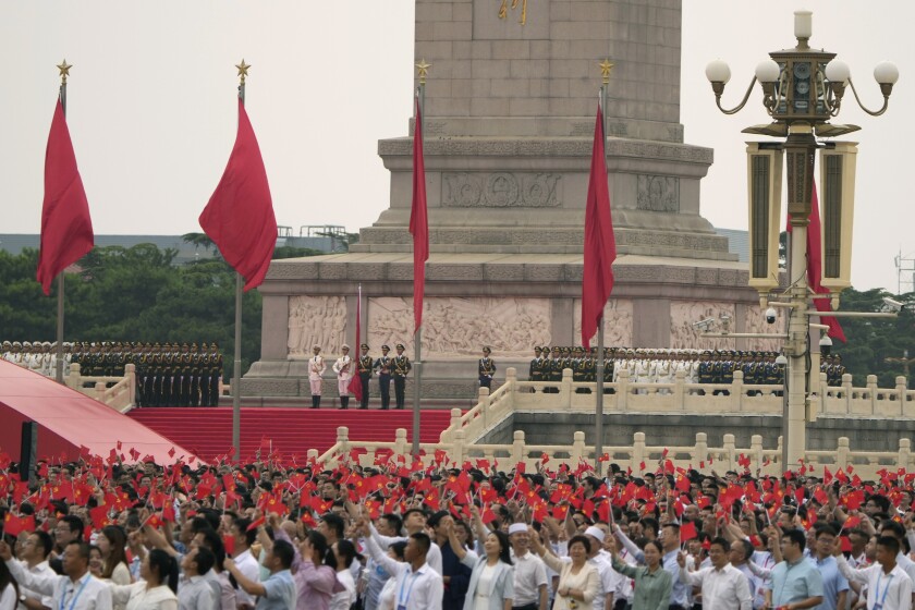 اعضای حزب کمونیست پرچم هایی را در میدان تیان آنمن به اهتزاز در آوردند