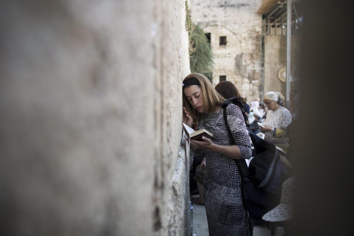A Jewish woman prays at the women's section of the Western Wall, Judaism's holiest site, in the Old City of Jerusalem, on July 28. The site has recently become a new religious battlefield between ultra-orthodox and Reform and Conservative movements of Judaism in light of a governmental plan to allow mixed gender prayers in a new section of the wall.