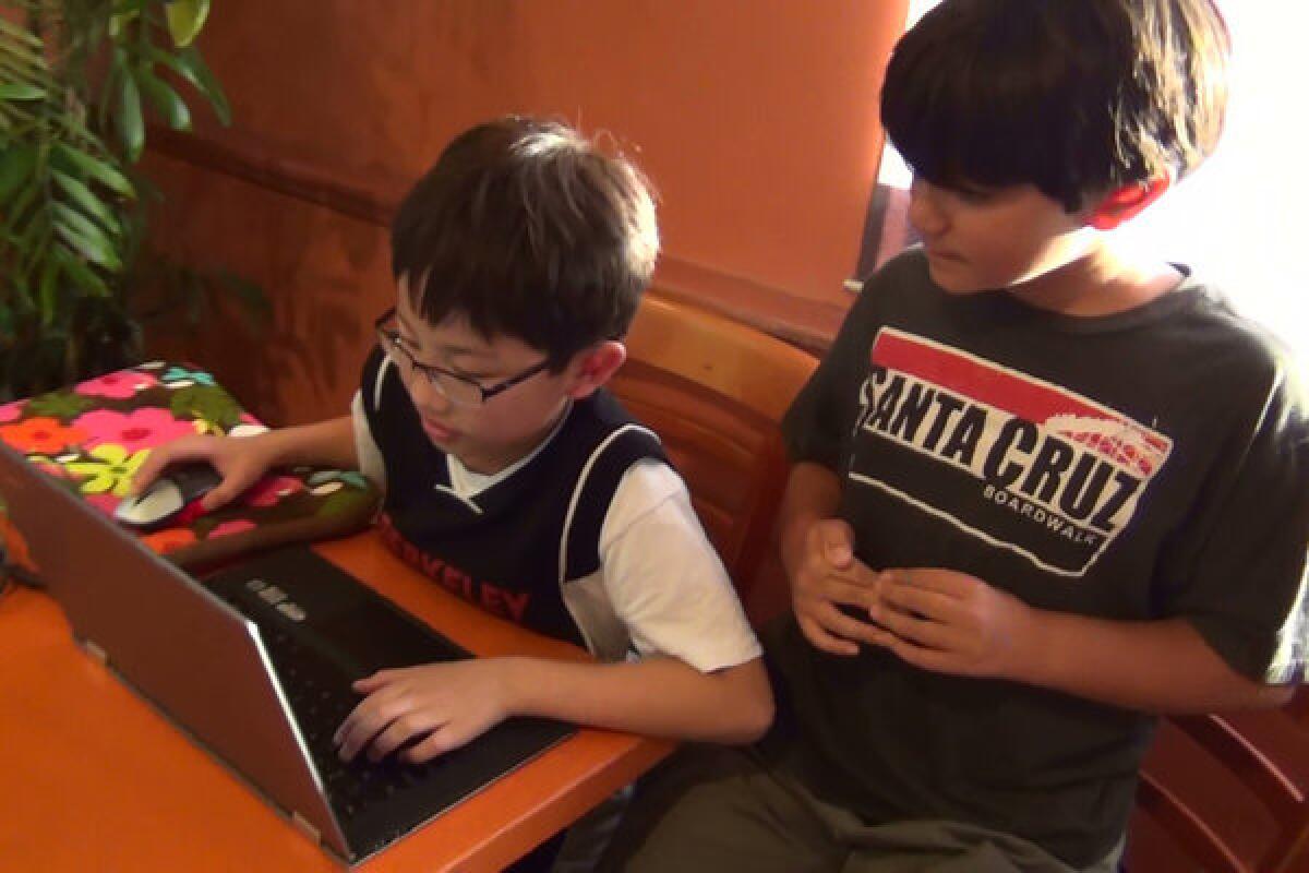 Kyle Kuwahara, left, and a friend are among a group of Berkeley fourth-graders who use the video game Minecraft to stay in touch with classmate Rodrigo Guzman, 10, who was deported along with his family to Mexico.