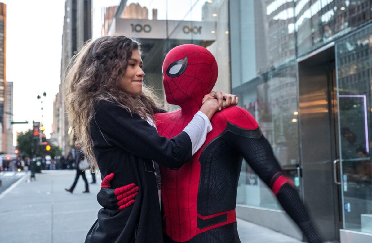 Tom Holland, in costume as Spider-Man, hugging Zendaya in "Spider-Man: Far From Home." 