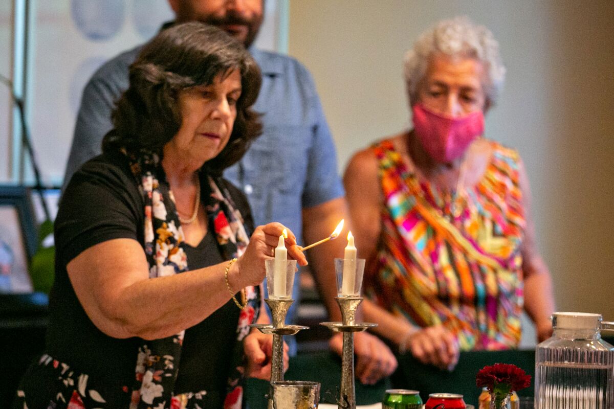 Pamela Taylor, an evacuee of the Caldor fire in South Lake Tahoe, lights candles as her family celebrates Rosh Hashanah.