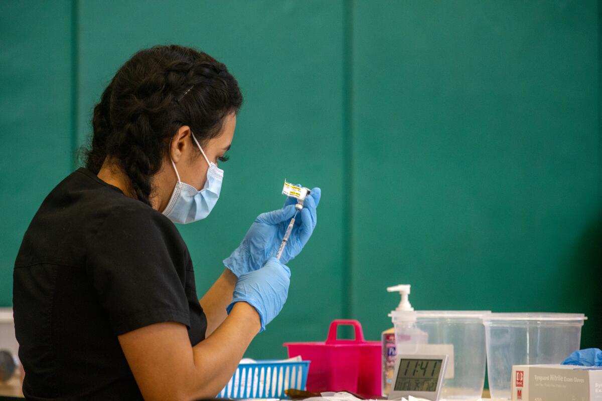 Nursing student Joanna Aguilar draws COVID-19 vaccine into a syringe at a temporary clinic in Wilmington last month.