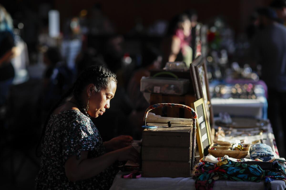 A woman sits behind her handmade items 