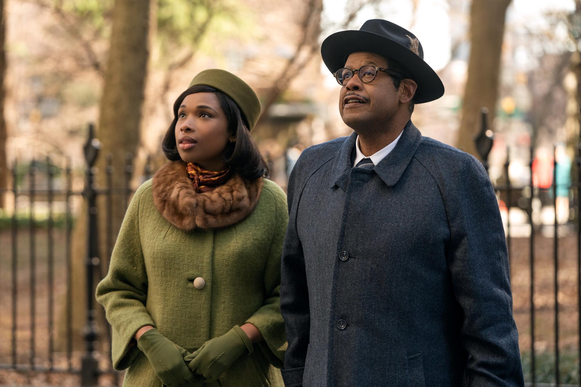 A woman in a dark green winter jacket and hat, left, and a man in a blue winter coat and nice hat. 