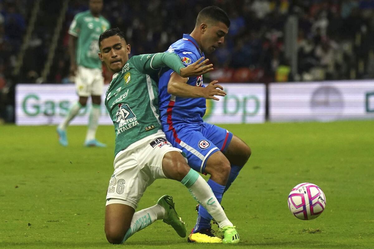 尝é辞苍's Fidel Ambríz and Cruz Azul's Erik Lira battle for the ball during a Liga MX match in Mexico City.