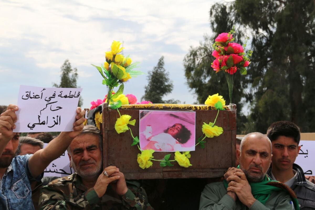 Iraqi Sameer Wais, right, carries the coffin of his daughter Fatima, 3, who was killed in an ISIS chemical attack on the town of Taza.