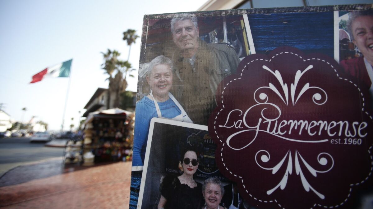 A poster at La Guerrerense in Ensenada shows owner Sabina Bandera with chef Anthony Bourdain, whose praise put the street food cart on the map.