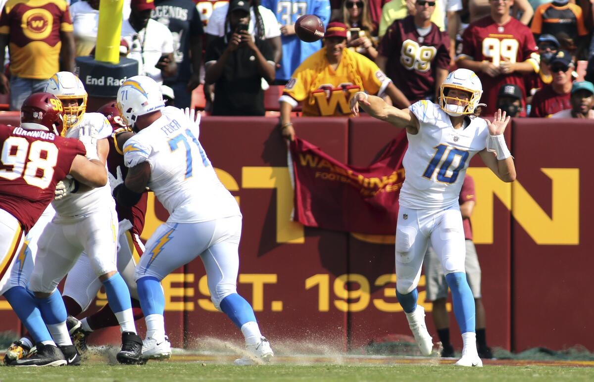 With a clear pocket, Chargers quarterback Justin Herbert (10) makes a throw against Washington.