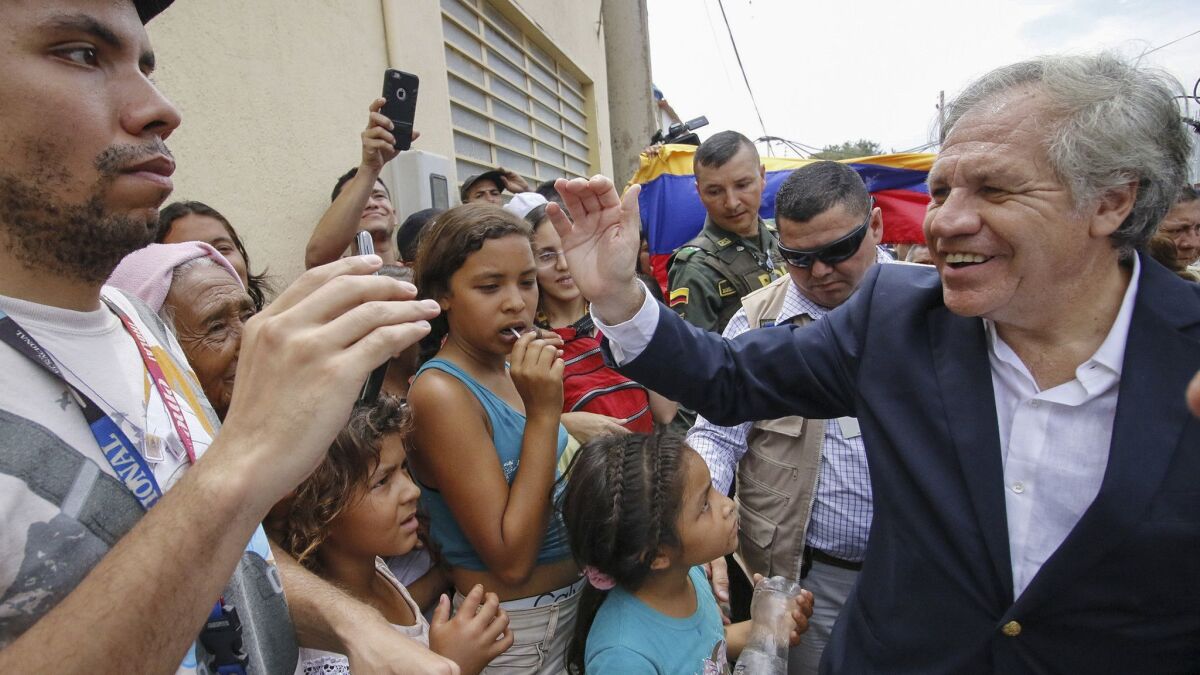 The Secretary-General of the Organization of American States, Uruguayan Luis Almagro, right, greets Venezuelans during his visit to the Divina Providencia migrant shelter in Cucuta, Colombia, on the border with Venezuela, on Sept. 14, 2018.