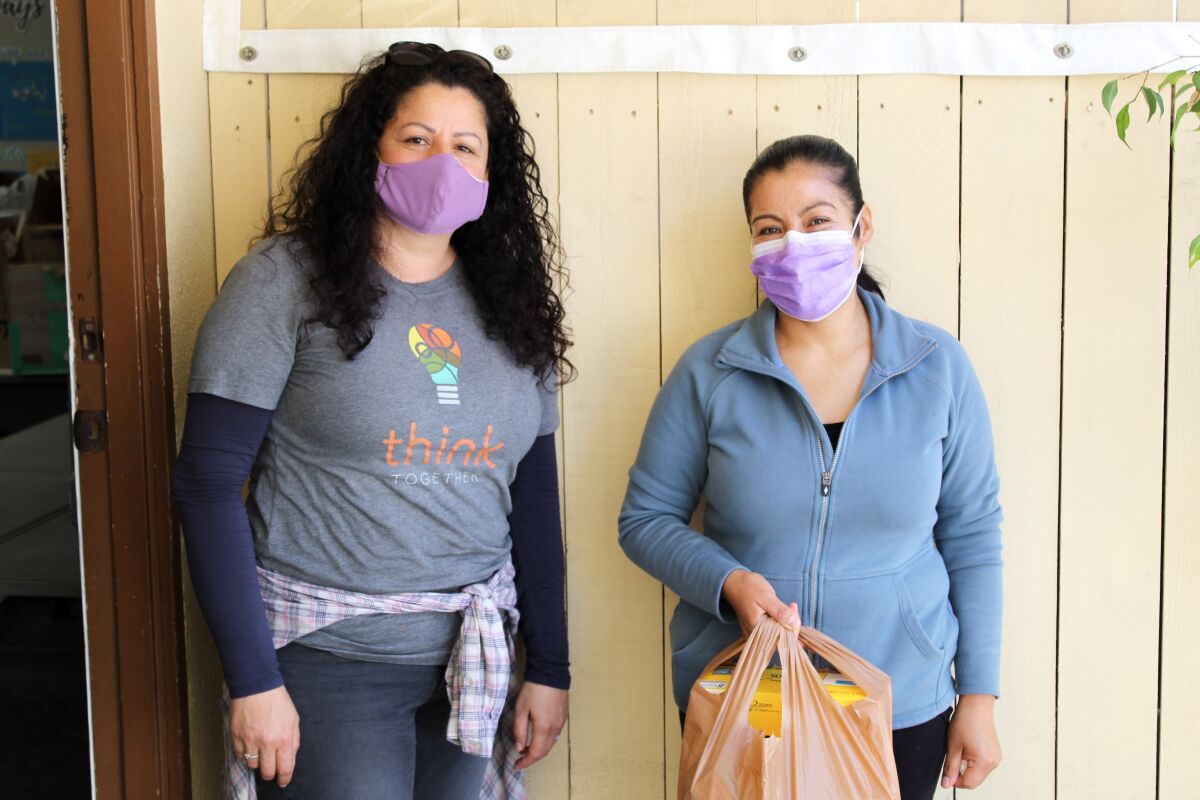 Emeteria Hernandez, right, receives supplies from Ruth Malagon. "I'm never going to forget," Hernandez said. "For them, I was able to have food that I didn’t have."