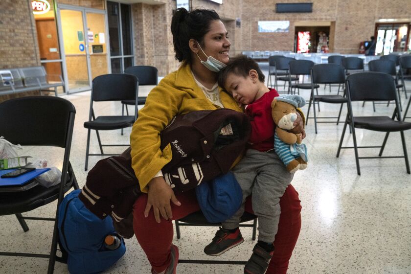 El Salvadoran asylum seeker Karla M. Rivera, 24, carries her son Mateo A. Rivera, 1, while they wait to be taken to the airport at a bus station in Brownsville, Texas on Thursday, Feb. 11, 2021. Veronica G. Cardenas / For The Times