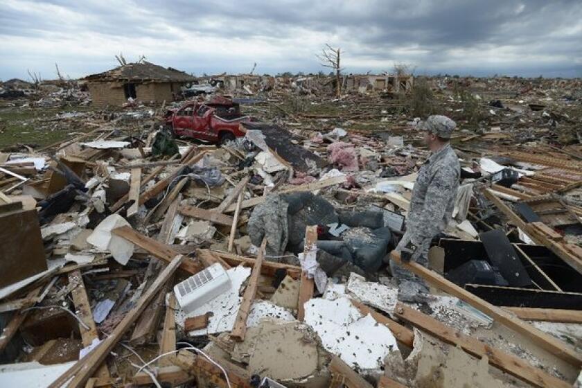 A resident of Moore, Okla., surveys damage left behind by the devastating tornado that passed through on Monday. It was the third megatornado to strike there since 1999.