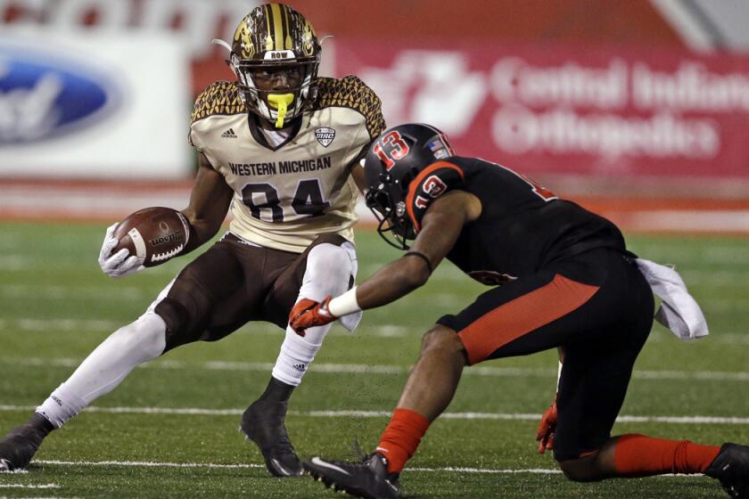 Western Michigan wide receiver Corey Davis, left, cuts away from Ball State cornerback David Moore during the second half Tuesday.