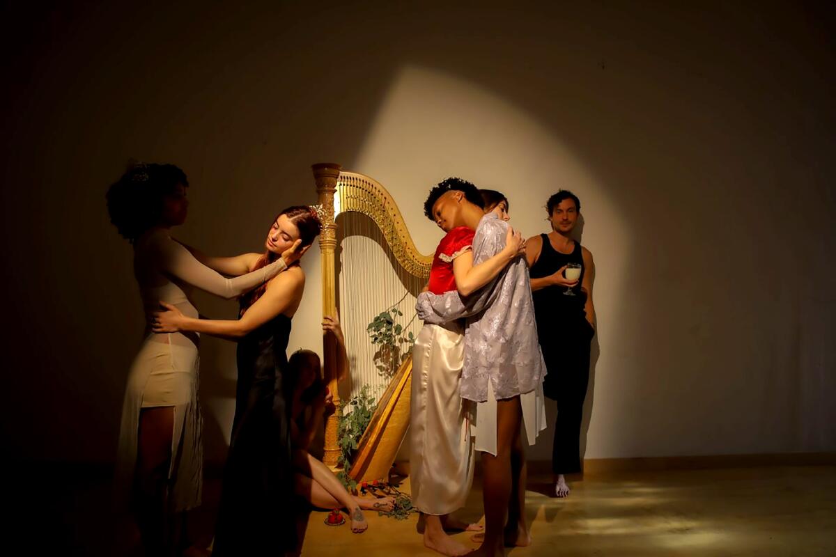Performers onstage pose separately and in couples near a harp.