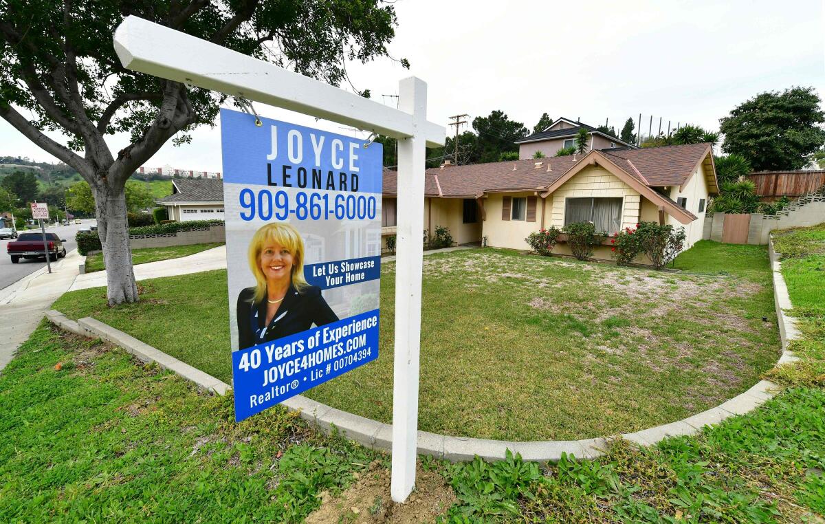  A Realtor service advertisement hangs outside a home.