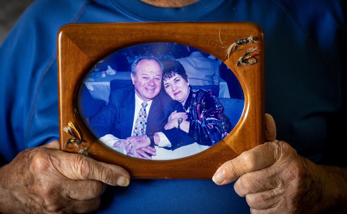 Erwin Goldbloom holds a photo showing him and his wife, Linda.