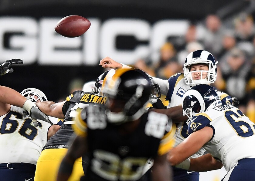 The Rams' realigned offensive line had difficulty protecting quarterback Jared Goff, who is hit by the Steelers as he releases a pass. 