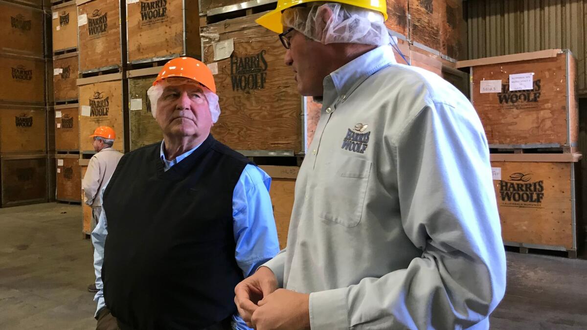 Agriculture Secretary Sonny Perdue, left, chats with Tom Carter, manager of the Harris Woolf California Almonds processing plant in Coalinga, Calif., during a tour on Feb. 14, 2018. (Geoffrey Mohan / Los Angeles Times)