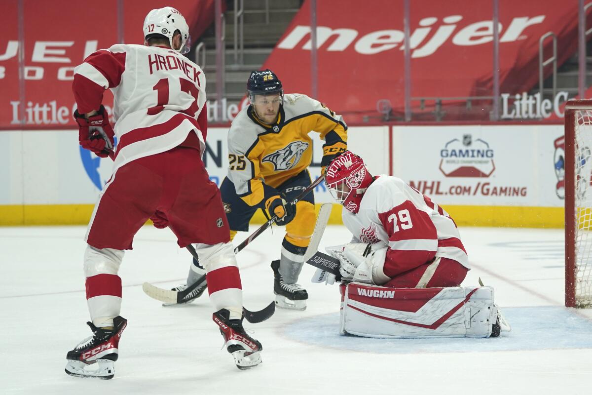 Detroit Red Wings goaltender Thomas Greiss (29) stops a Nashville Predators right wing Mathieu Olivier (25) shot as Filip Hronek (17) defends in the first period of an NHL hockey game Tuesday, April 6, 2021, in Detroit. (AP Photo/Paul Sancya)