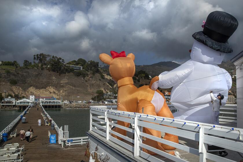 MALIBU, CA-NOVEMBER 28, 2022: A giant inflatable reindeer and snowman are displayed outside Ranch at the Pier, a convenience store located on the Malibu Pier in Malibu. Public health officials issued a cold weather alert for parts of Los Angeles County, where overnight temperatures are expected to drop below freezing today and throughout the week. (Mel Melcon / Los Angeles Times)