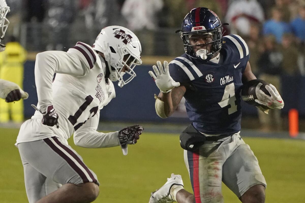 Mississippi running back Quinshon Judkins (4) looks to fend off Mississippi State safety Shawn Preston Jr. (12) during the second half of an NCAA college football game in Oxford, Miss., Thursday, Nov. 24, 2022. Mississippi State won 24-22. (AP Photo/Rogelio V. Solis)