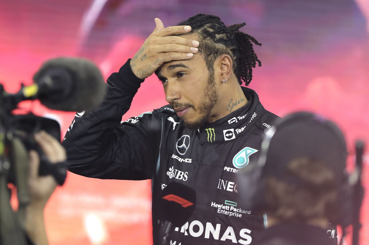 FILE - Mercedes driver Lewis Hamilton of Britain reacts after finishing second in the Formula One Abu Dhabi Grand Prix in Abu Dhabi, United Arab Emirates, Sunday, Dec. 12. 2021. After losing the Formula One title on the last lap last year, Lewis Hamilton is more motivated than ever to wrestle it back from Max Verstappen. But Hamilton’s also worried that Mercedes is not quick enough to win races and that both Verstappen’s Red Bull team and Ferrari could be the early pace-setters when the season begins Sunday, March 20, 2022 in Bahrain. (AP Photo/Kamran Jebreili, Pool, File)