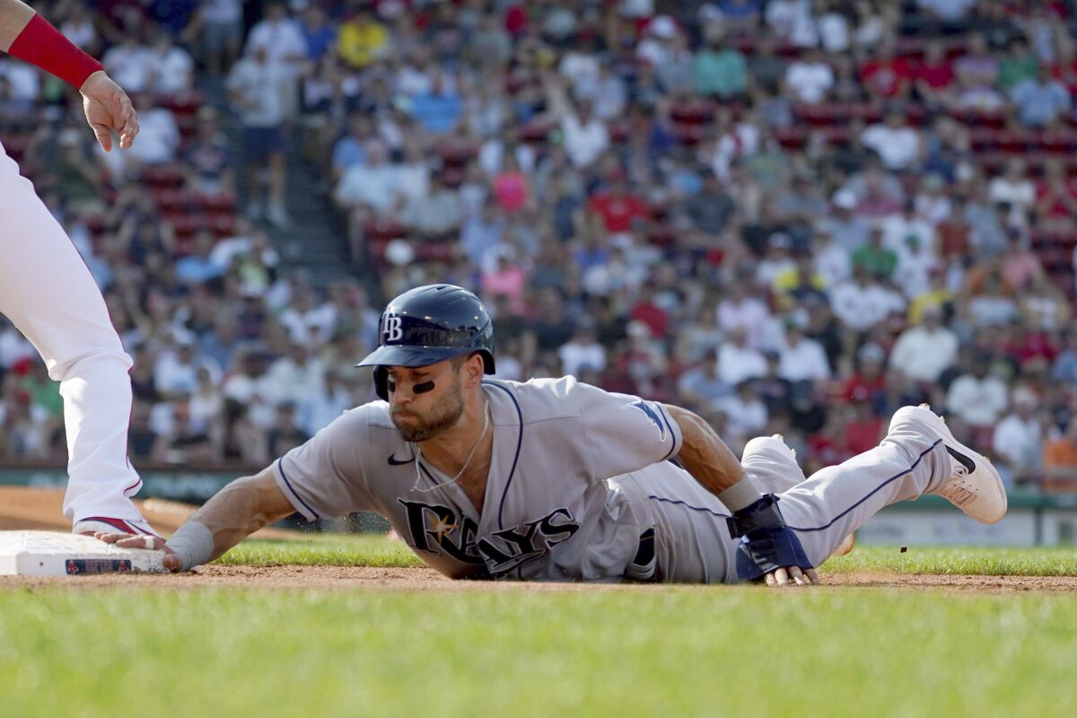 Tampa Bay Rays baserunner Kevin Kiermaier (39) dives back to first on a pick off attempt by Boston Red Sox first baseman Marwin Gonzalez during the third inning of a baseball game at Fenway Park, Thursday, Aug. 12, 2021, in Boston. (AP Photo/Mary Schwalm)