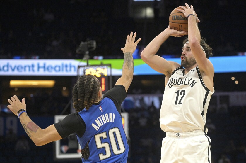 Brooklyn Nets forward Joe Harris (12) goes up for a shot in front of Orlando Magic guard Cole Anthony (50) during the first half of an NBA basketball game Wednesday, Nov. 10, 2021, in Orlando, Fla. (AP Photo/Phelan M. Ebenhack)