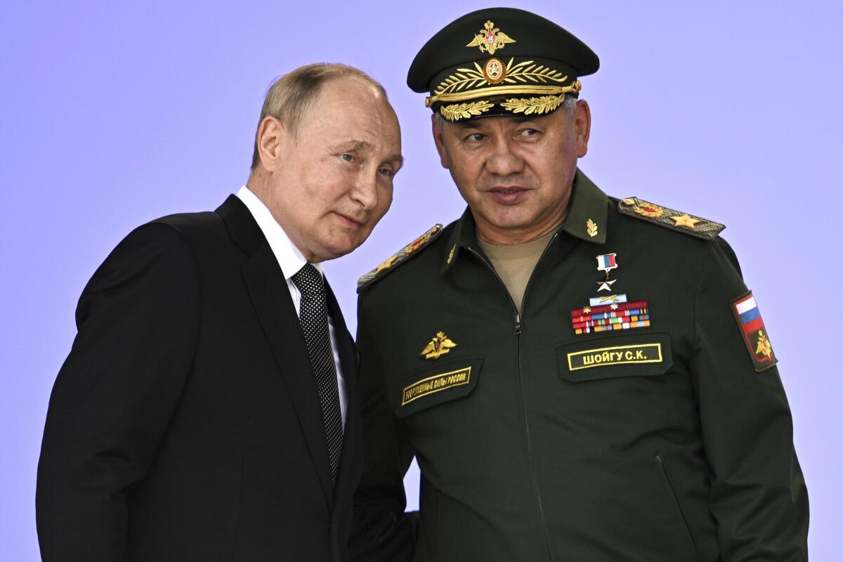 Russian President Vladimir Putin stands with Russian Defense Minister Sergei Shoigu