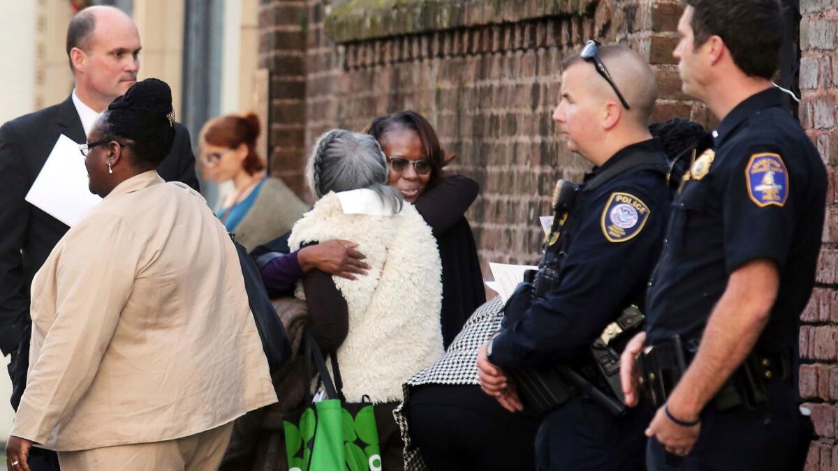 Emanuel AME shooting survivor Felicia Sanders, center, receives a hug after a short church service for the families at St. Michaels Church across from federal court in Charleston, S.C.