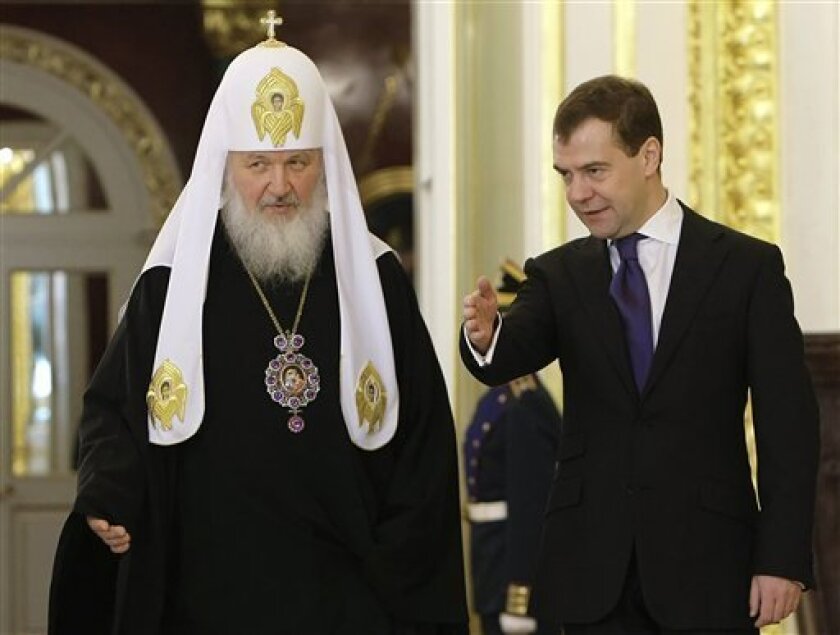 In this Feb. 2, 2009 file photo, Russian Orthodox Church Patriarch Kirill, left, and Russian President Dmitry Medvedev enter St. George Hall at the Kremlin for the official reception for participants of the Russian Orthodox Church Civil Council in Moscow, Russia. (AP Photo/RIA Novosti, Dmitry Astakhov, Presidential Press Service, file)