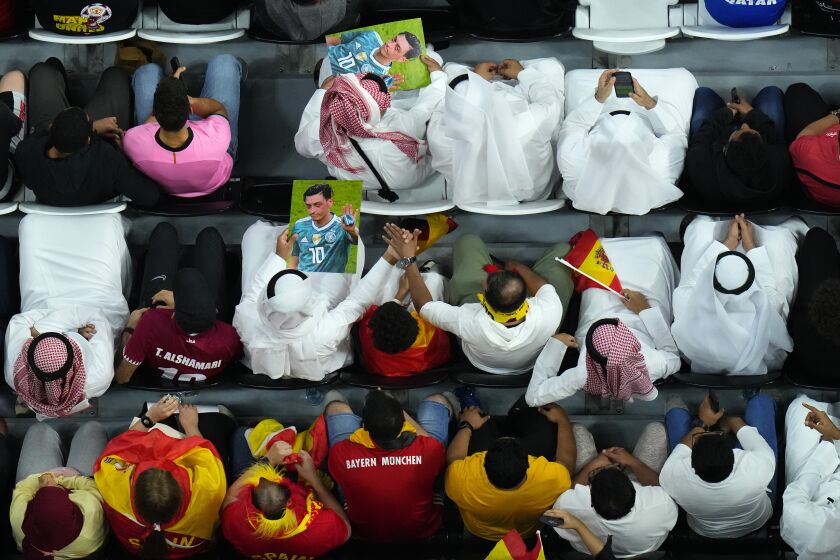 Spectators hold photos of Forman German international Mesut Ozil in the stands during the World Cup group E soccer match between Spain and Germany, at the Al Bayt Stadium in Al Khor , Qatar, Sunday, Nov. 27, 2022. (AP Photo/Petr David Josek)