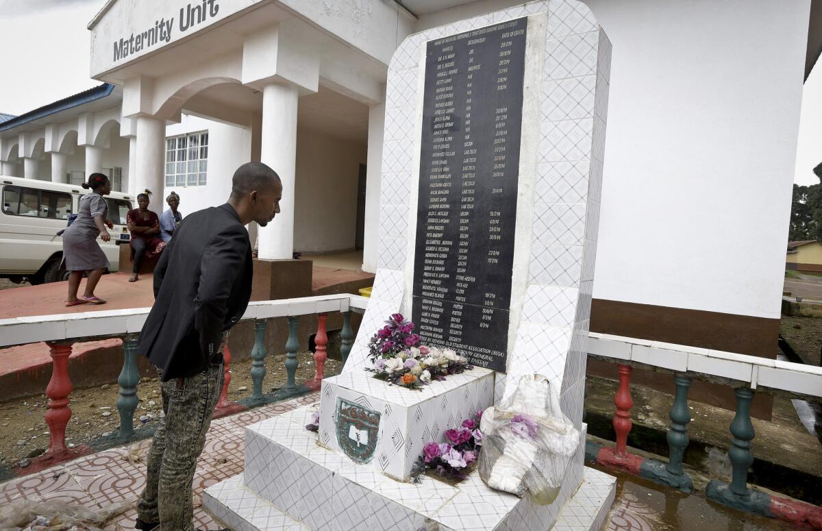 In this Saturday, Aug. 8, 2015 photo, a man reads a monument with the names of health workers who died of Ebola at the government hospital in Kenema, eastern Sierra Leone.