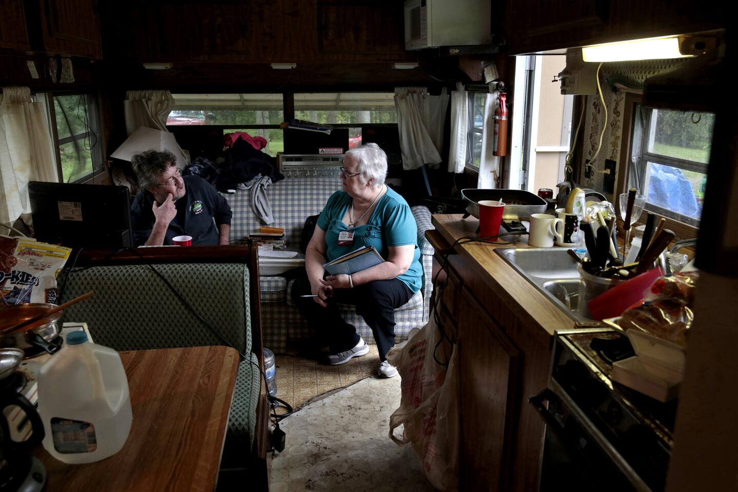 Nurse Sally Patterson goes over medical information at the trailer home of David Smith of Carmel, Maine. Patterson makes such visits across a wide swath of the northern section of the state, part of a collaborative effort among businesses and health workers to help patients live healthier lives and stay out of the hospital.