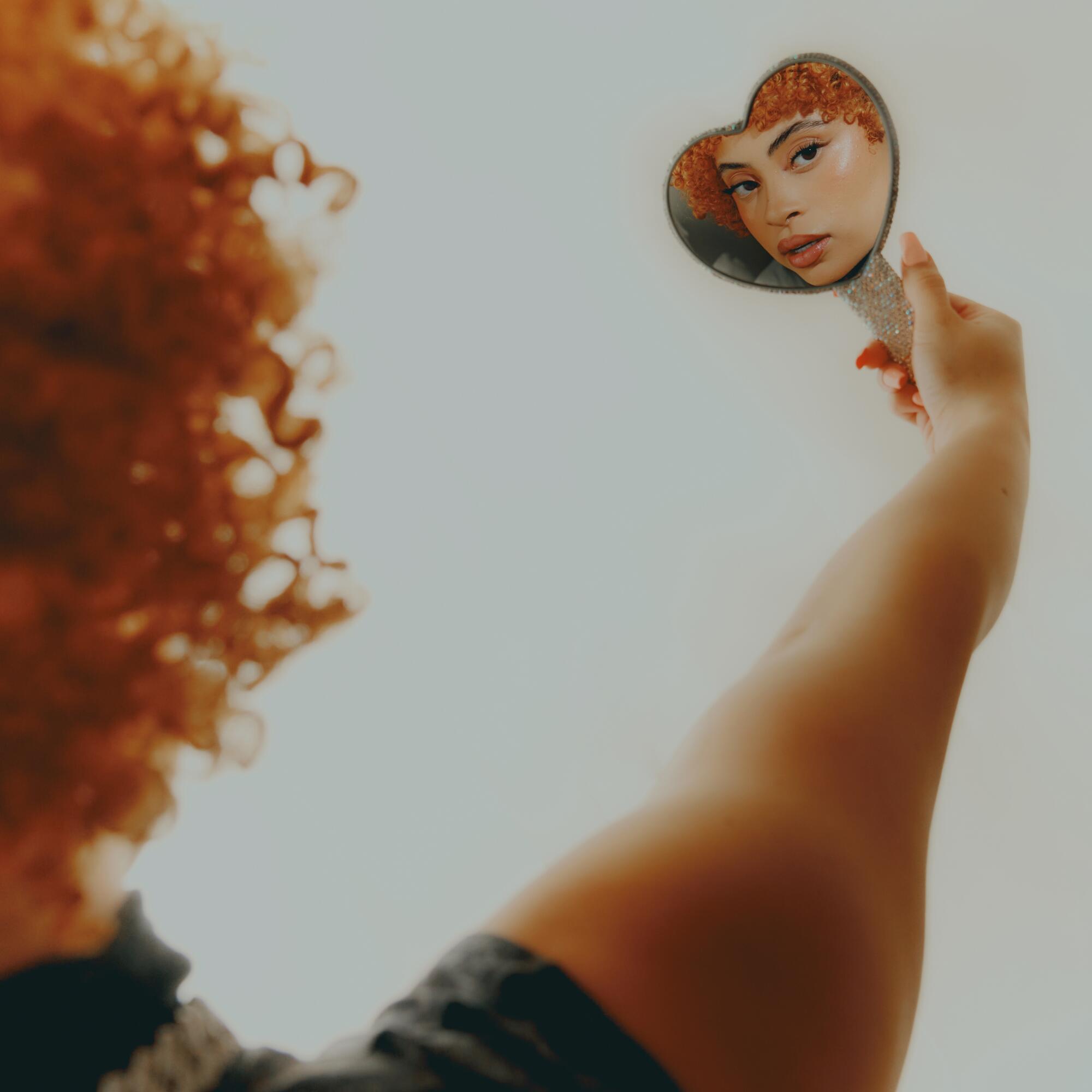 Una estrella del rap mira su imagen en un espejo con forma de corazón