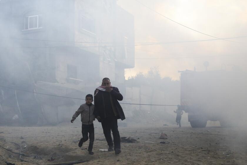 Palestinians run away after an Israeli strike on a residential building in Rafah, Monday, Feb. 19, 2024. (AP Photo/Hatem Ali)