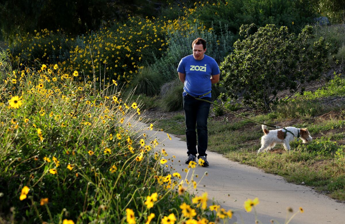 Tristan Bielecki and his dog Brownie enjoy the blooming flowers on the lower level of Ascot Hills.