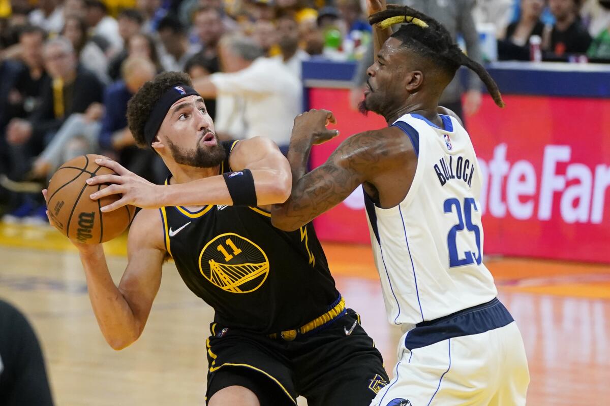 Golden State Warriors guard Klay Thompson is defended by Dallas Mavericks guard Reggie Bullock.