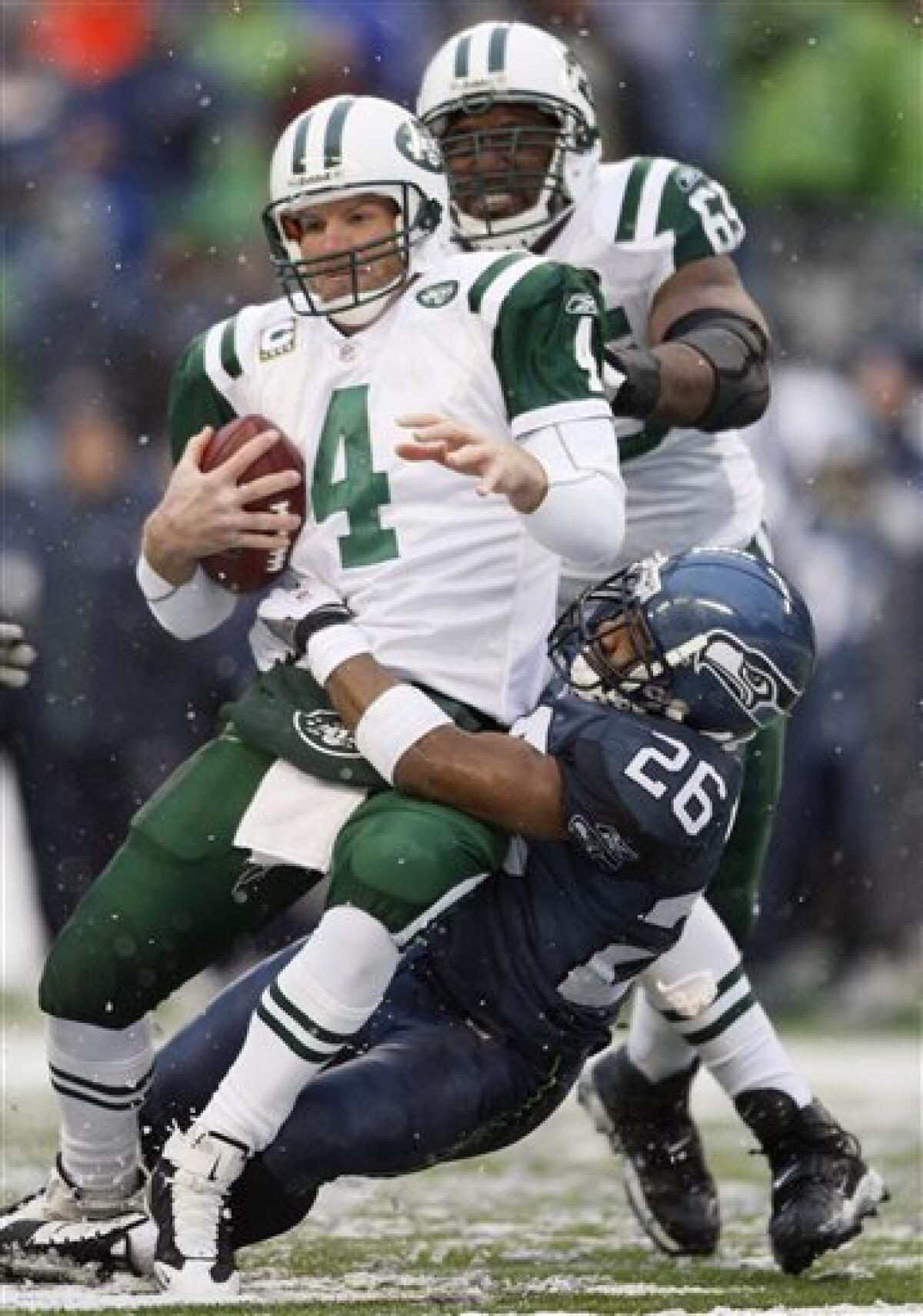 FILE - In this Dec. 21, 2008, file photo, New York Jets quarterback Brett Favre is sacked by Seattle Seahawks cornerback Josh Wilson (26) as Jets' Brandon Moore looks on from rear during an NFL football game in Seattle. Favre was released from the reserve-retired list by the Jets on Tuesday night, April 28, 2009, making the quarterback a free agent if he decides to again come out of retirement. (AP Photo/John Froschauer, File)