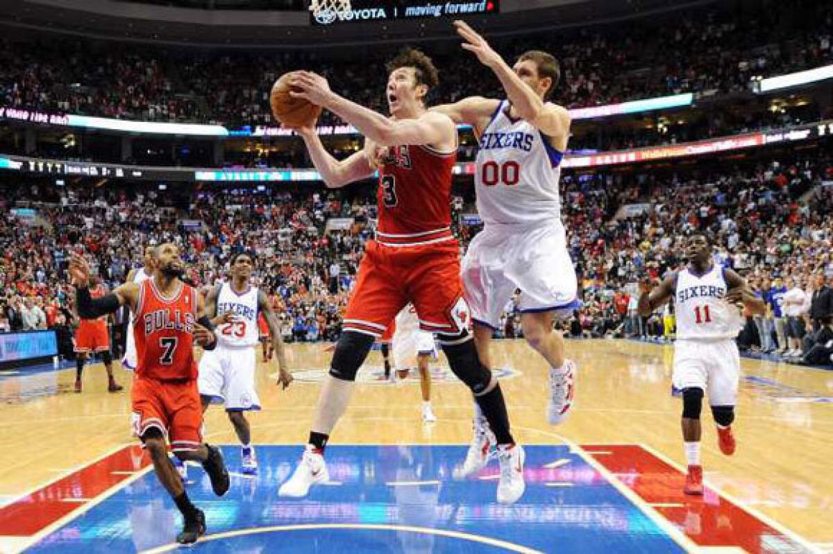 Omer Asik of the Bulls is fouled by Spencer Hawes of the 76ers near the end of Game 6.