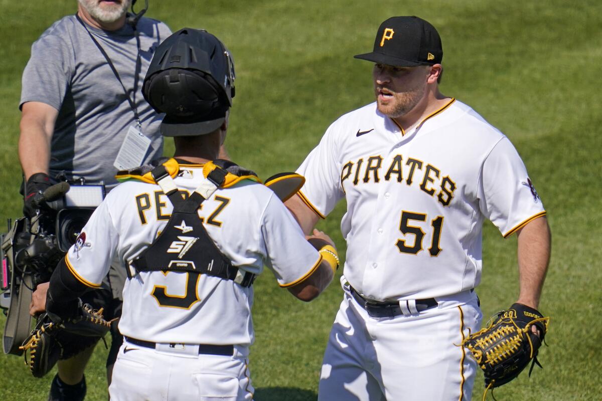Pittsburgh Pirates relief pitcher David Bednar celebrates with catcher Michael Perez after the final out.