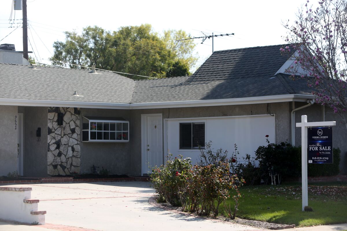 A house with a "For Sale" sign